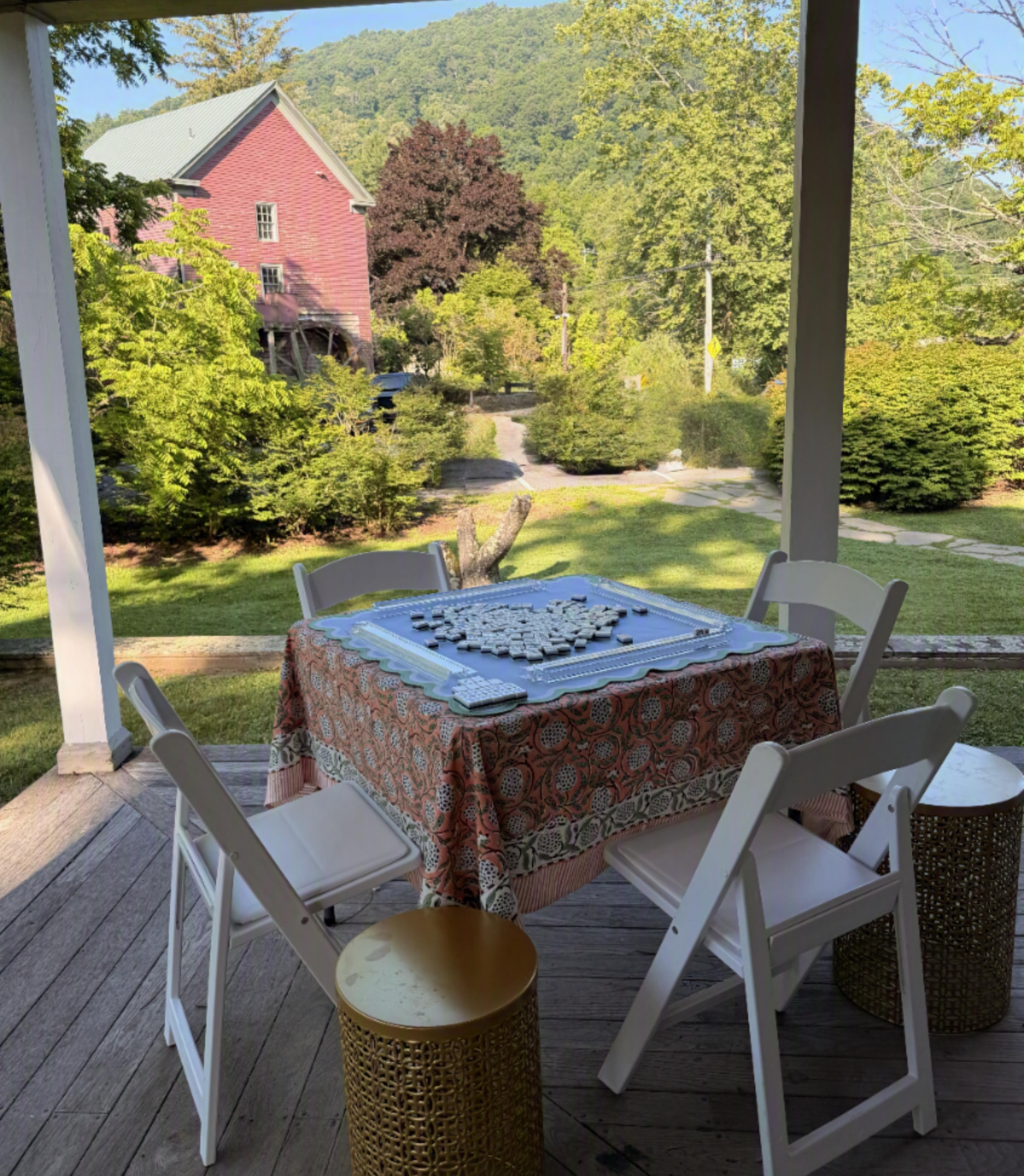 Porch game table overlooking red farmhouse
